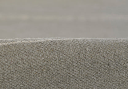 Close-up of gray loop-pile carpet edge, textured wool-like upholstery fabric, neutral-modern style.