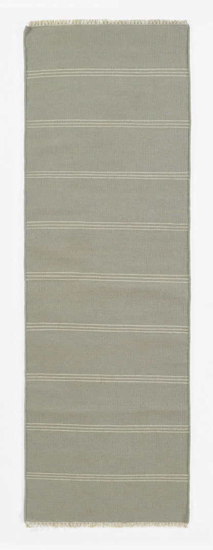 Beige-gray woven rug runner with subtle horizontal white stripes and fringed ends.
