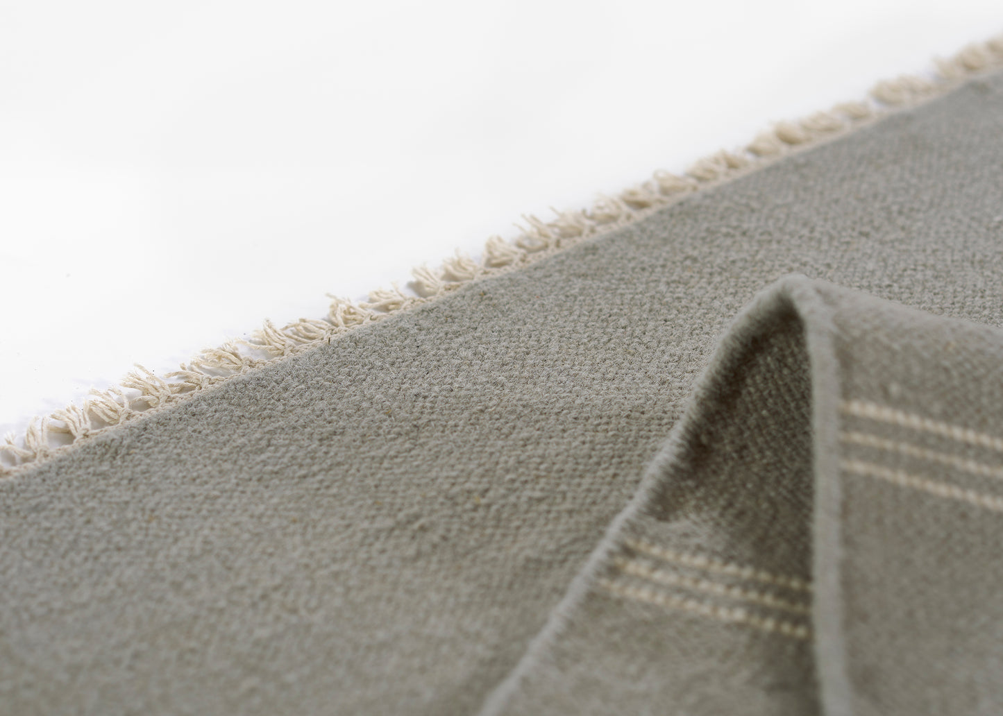Gray woven runner rug with beige fringe along edges, soft textured weave, 3' x 8'.