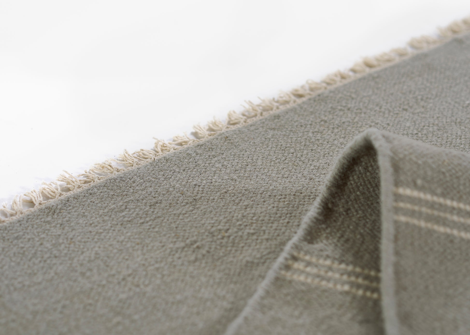 Gray woven runner rug with beige fringe along edges, soft textured weave, 3' x 8'.