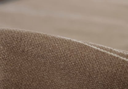 Close-up of brown textured boucle rug with white edge trim