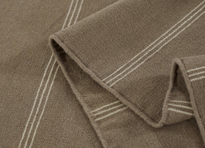 Brown taupe rug runner (3' x 8') with white double stripes along the edge, plush pile, folded.