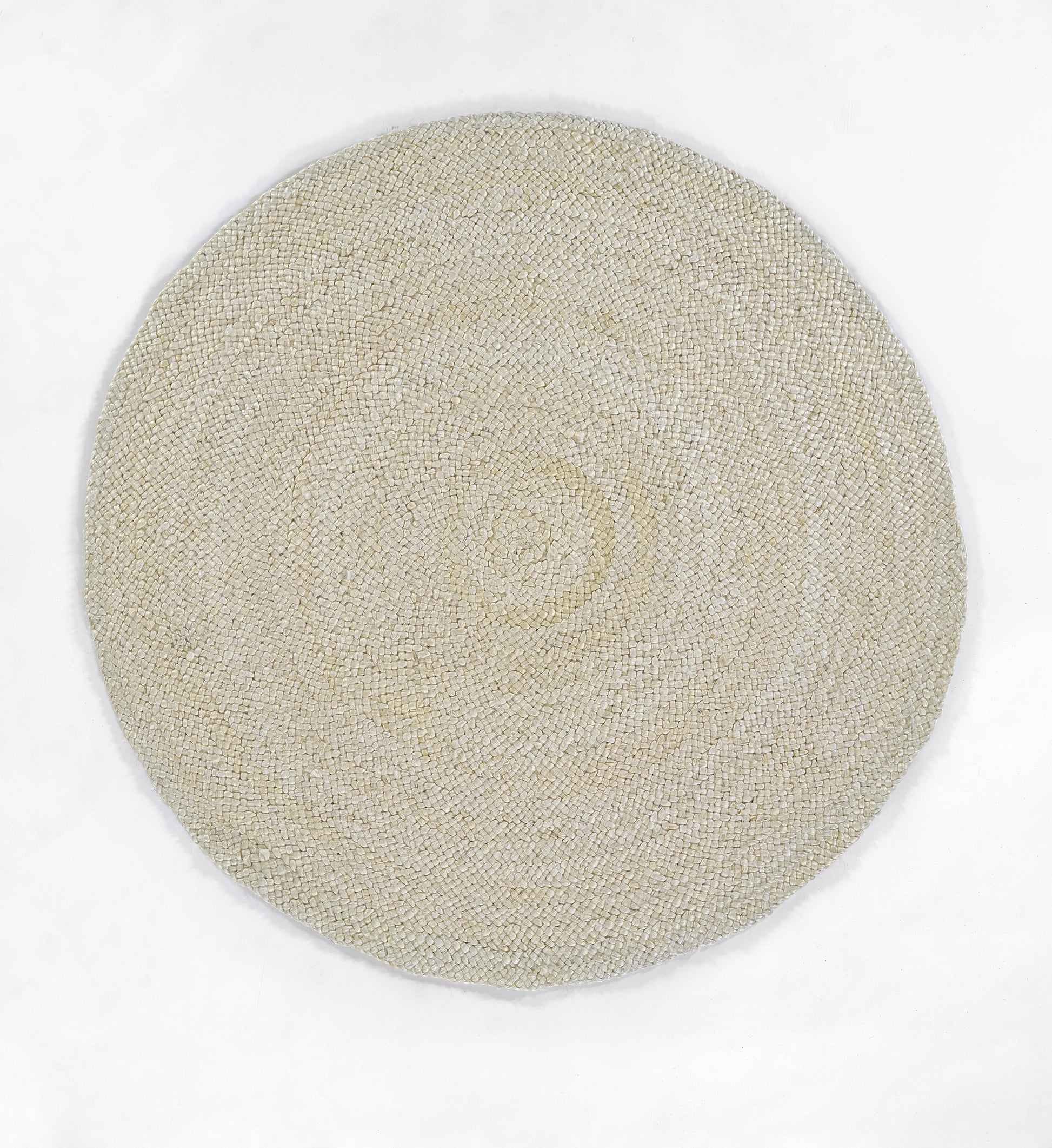 Beige natural jute rug with tight circular woven texture, flat-weave, artisanal coastal style.