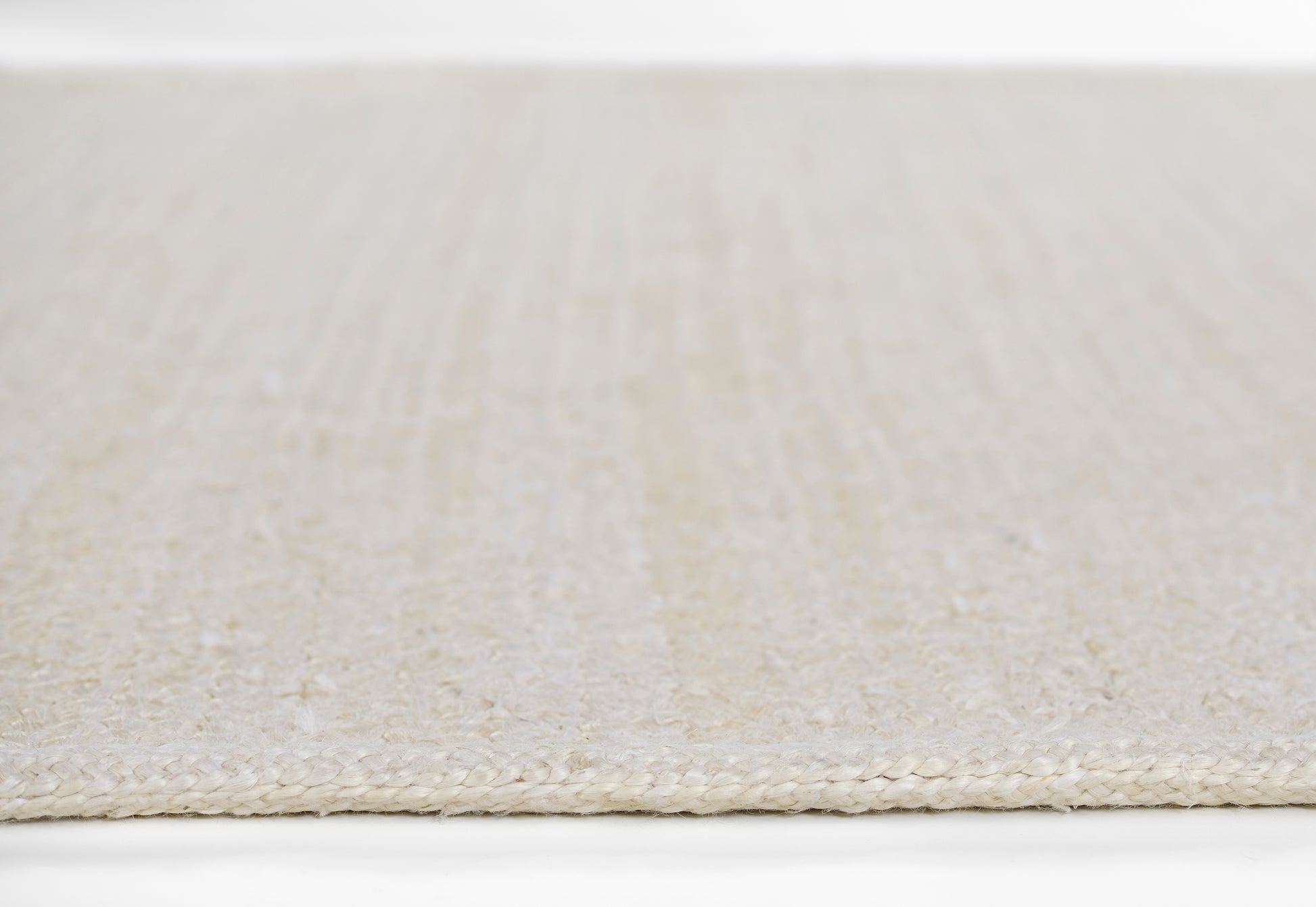 Beige woven area rug with a cream-toned braided edge and a textured striped surface, 8' x 11'.