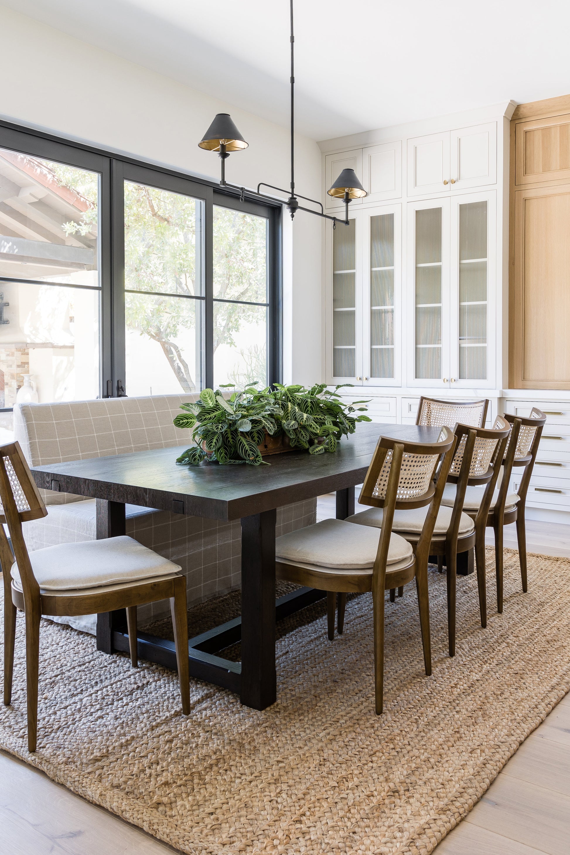 Natural jute braided runner rug (2'6" x 8') laid under a dark wood dining table with beige upholstered chairs and a bench.