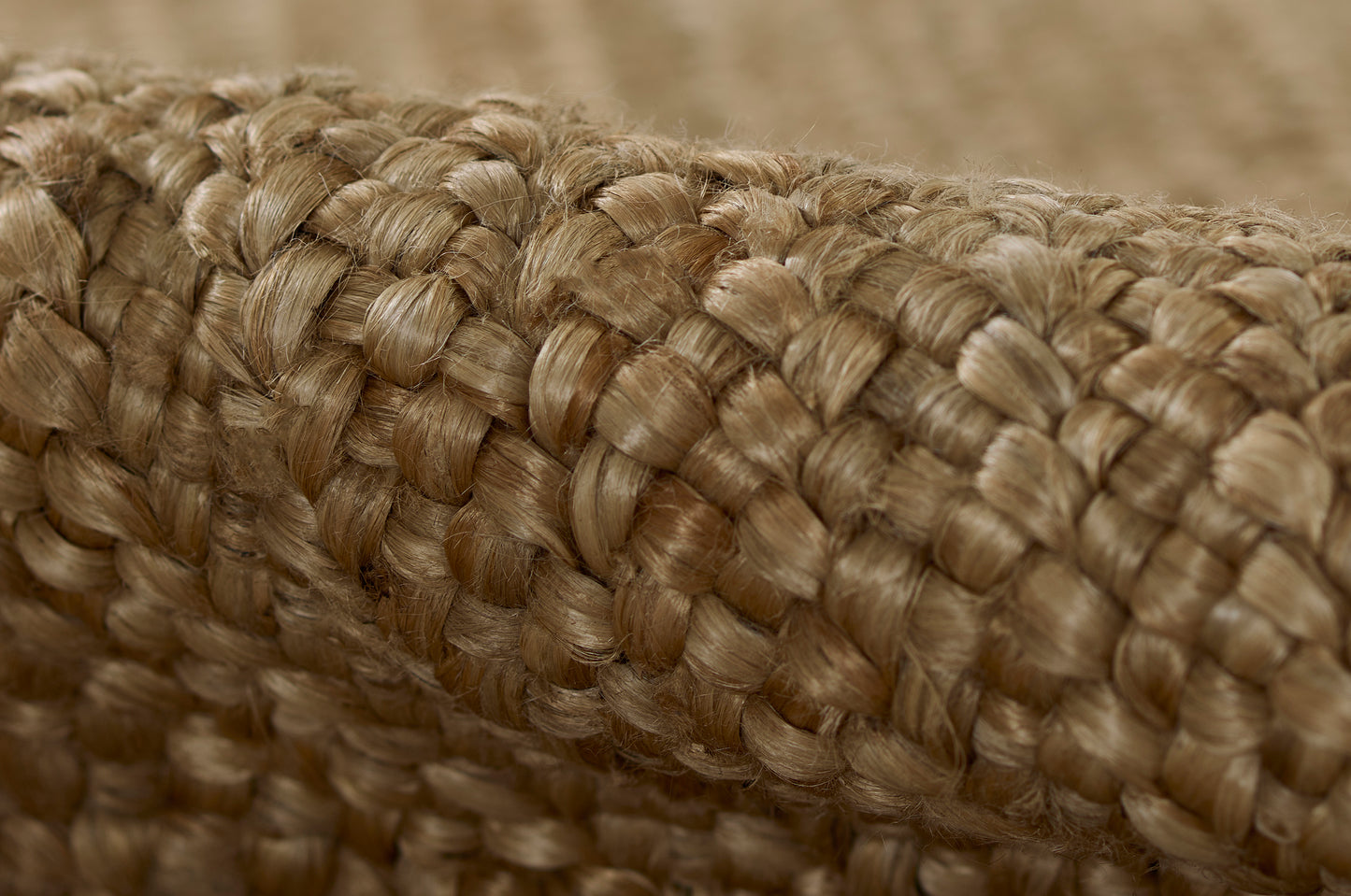 Close-up of thick natural jute rope; braided, warm beige tones, rustic decor accessory.