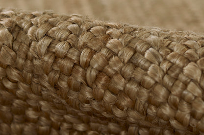 Close-up of thick natural jute rope; braided, warm beige tones, rustic decor accessory.