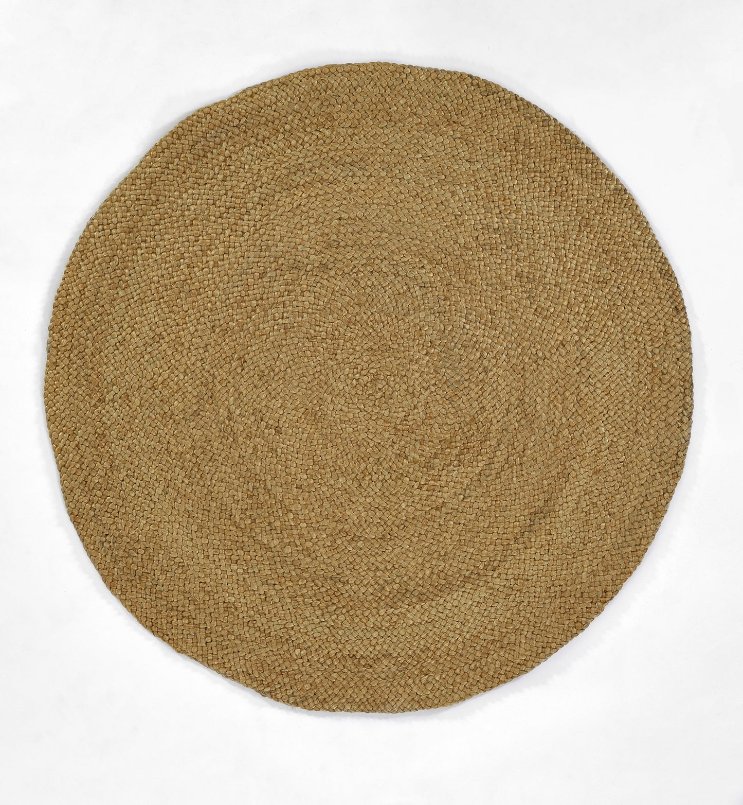 Natural round jute rug with tight woven texture in tan; coastal rustic floor decor.