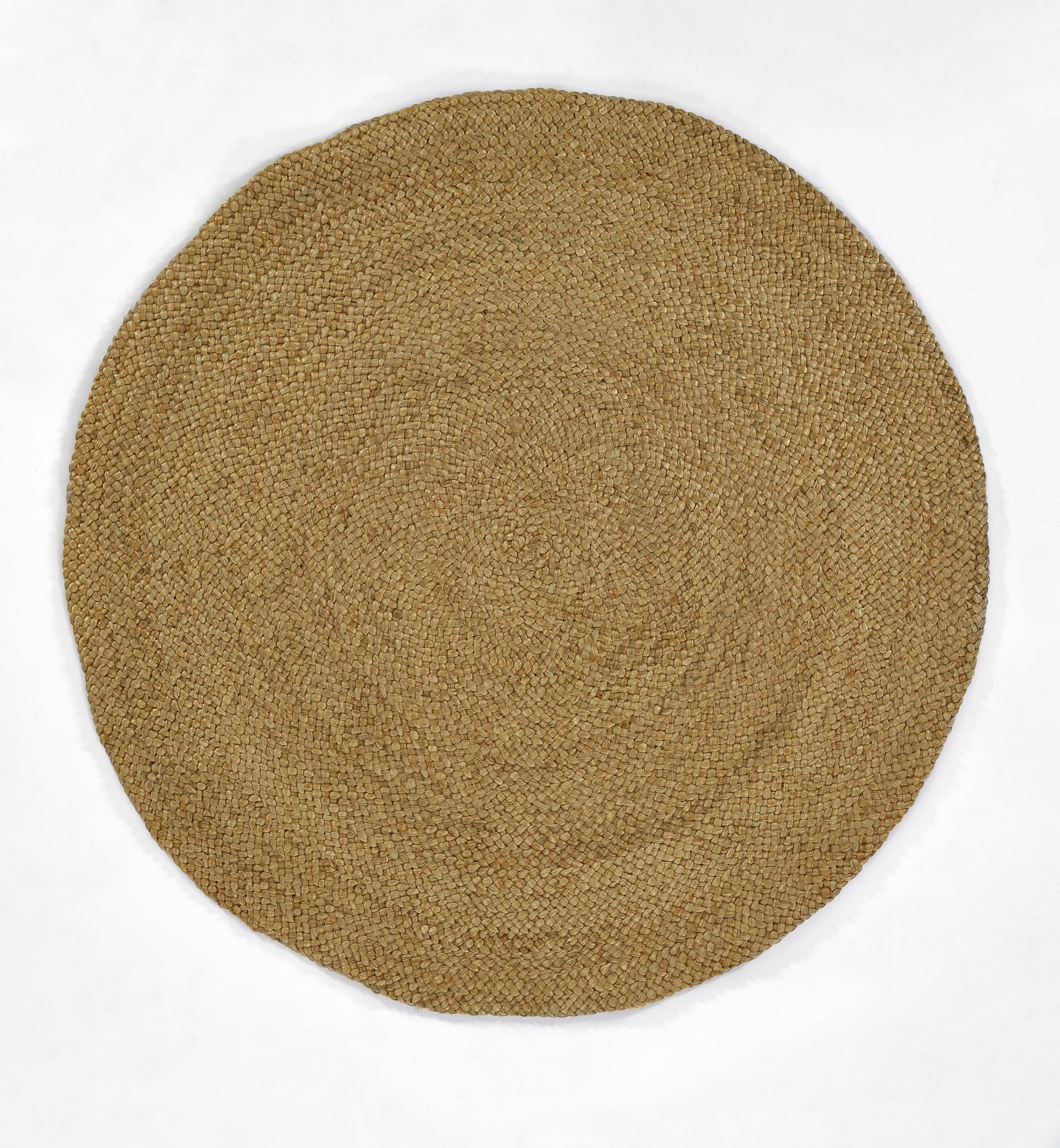 Natural round jute rug with tight woven texture in tan; coastal rustic floor decor.