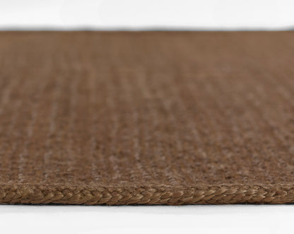 Brown braided-edge sisal runner, close-up of textured flat-weave fibers.