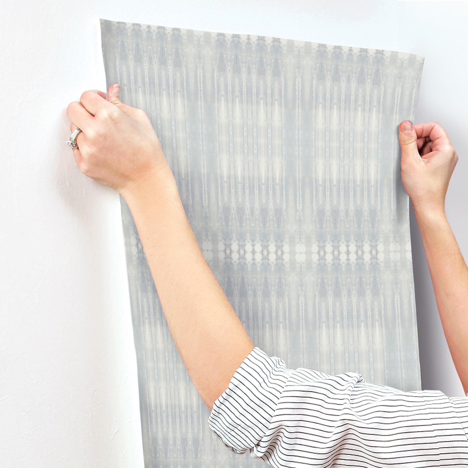 Blue-grey wall mural with vertical ikat-like geometric patterns.
