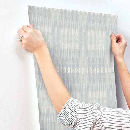 Blue-grey wall mural with vertical ikat-like geometric patterns.