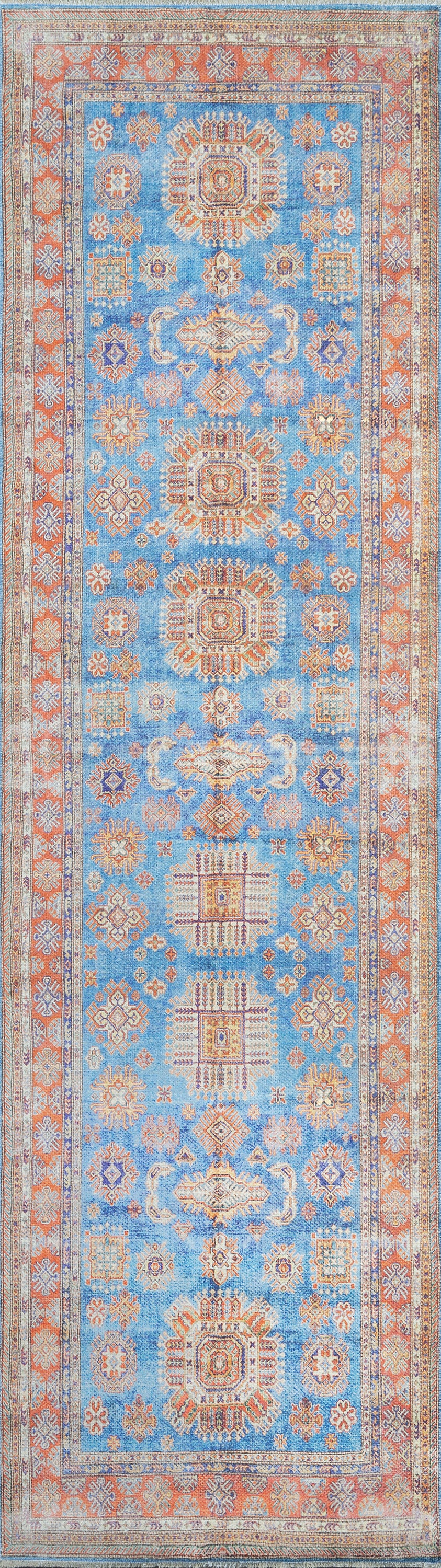 Persian-style rug; blue field with orange border, geometric center medallions in cream & rust, decorative floral motifs.