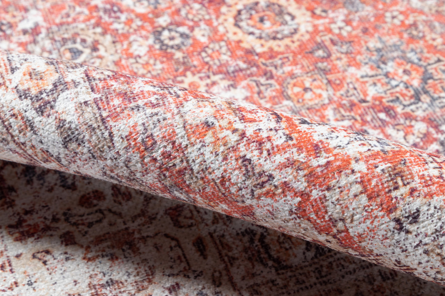 Persian-style wool rug in red, ivory & navy with intricate floral medallions; rolled edge visible.