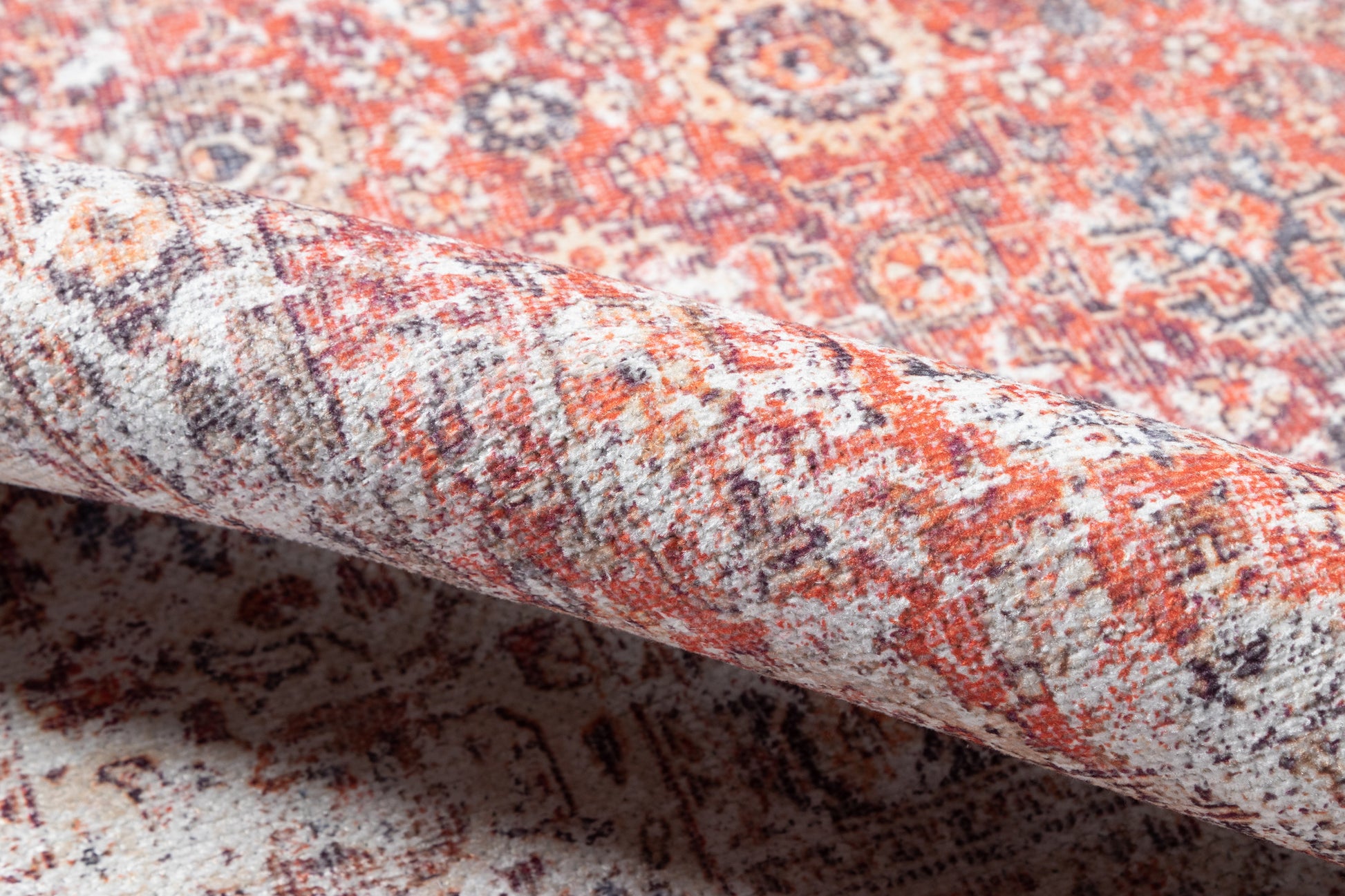 Persian-style wool rug in red, ivory & navy with intricate floral medallions; rolled edge visible.