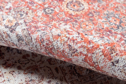Persian-style wool rug in red, ivory & navy with intricate floral medallions; rolled edge visible.