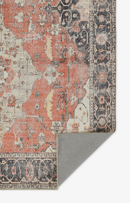 Antique oriental rug with coral field, navy border & cream motifs; distressed pattern, folded corner shows grey backing.