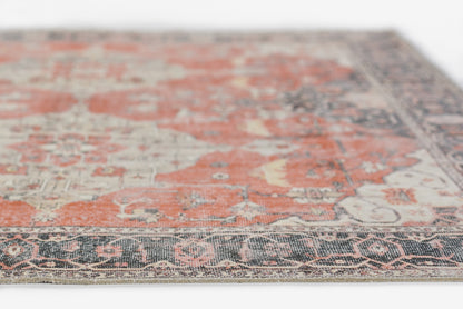 Persian-inspired rug with burnt orange and cream motifs, navy border, intricate floral pattern, angled close-up.