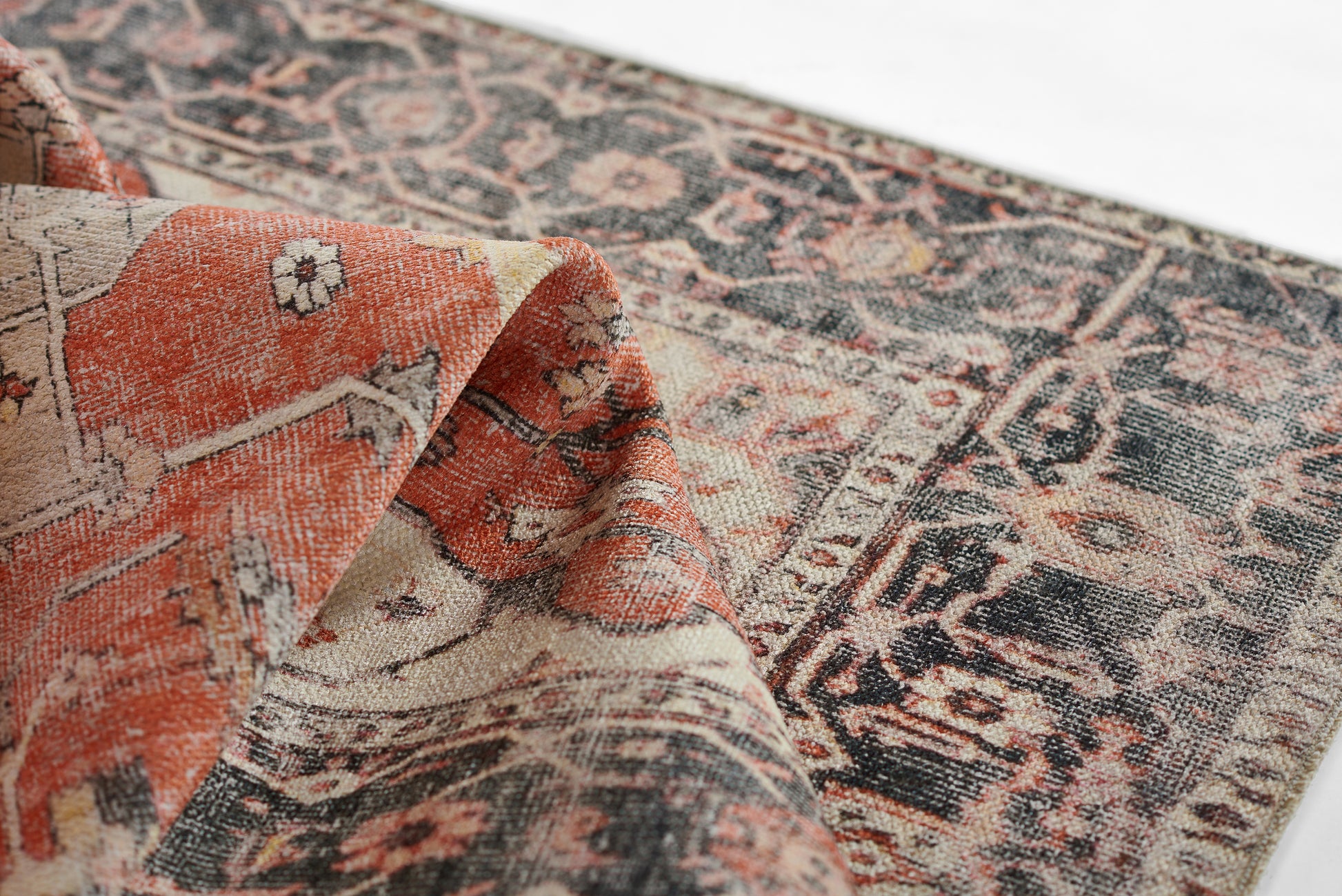 Wool rug in orange, cream and navy with a distressed Persian-style pattern and ornate bordered edges.