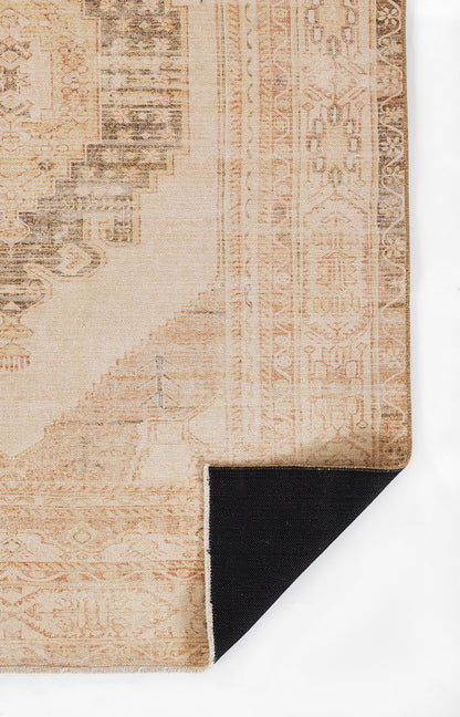 Beige vintage oriental rug with faded pink medallion motifs and geometric border; corner folded to reveal black backing.