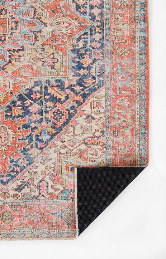 Persian-style rug with coral, navy, blue and cream; intricate geometric florals and border, folded corner shows underside.