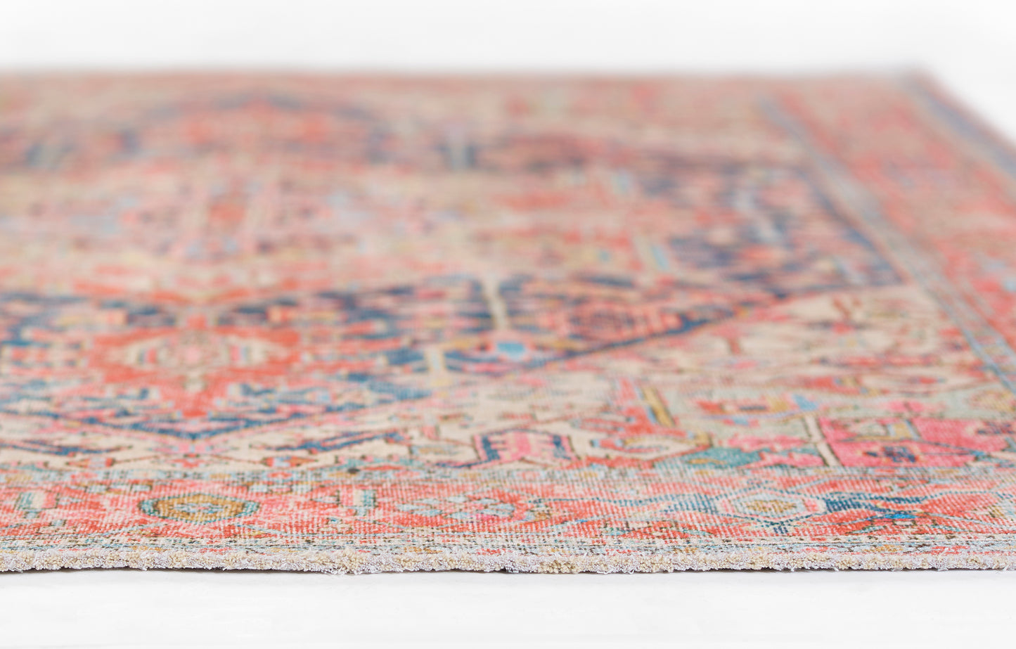 Multi-color Persian-style rug with red, blue & ivory hues, distressed vintage look, fringe edge.