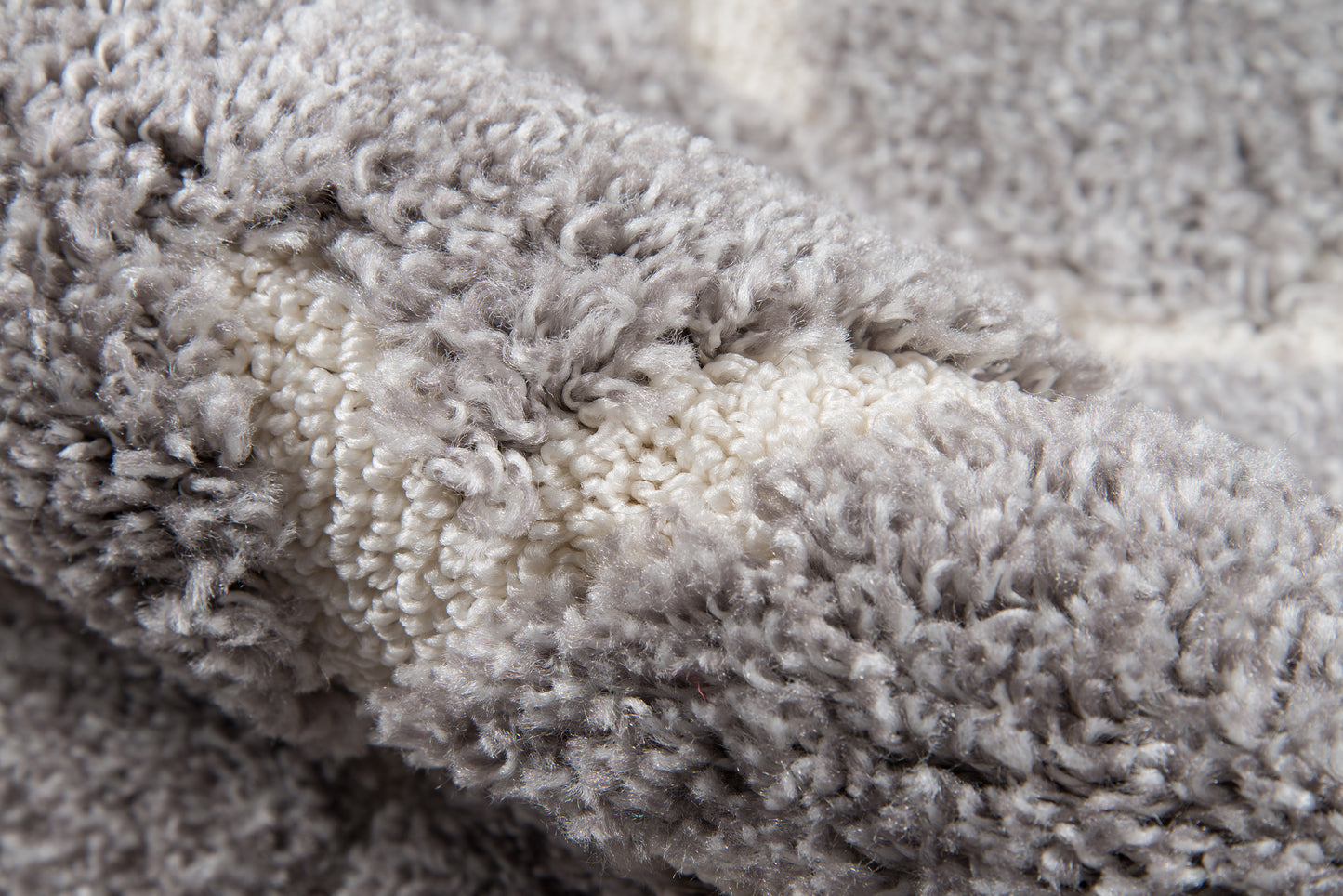 Grey and ivory plush shag rug with thick, fluffy pile—cozy throw-style floor cover.