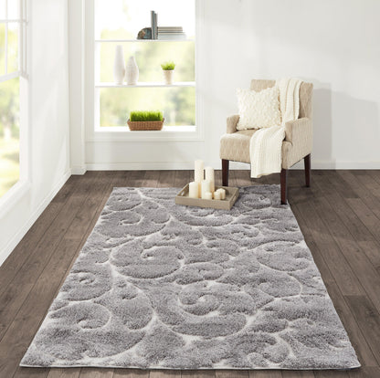Rectangular gray shag area rug with a swirling pattern, placed in a bright living room beside a beige armchair.