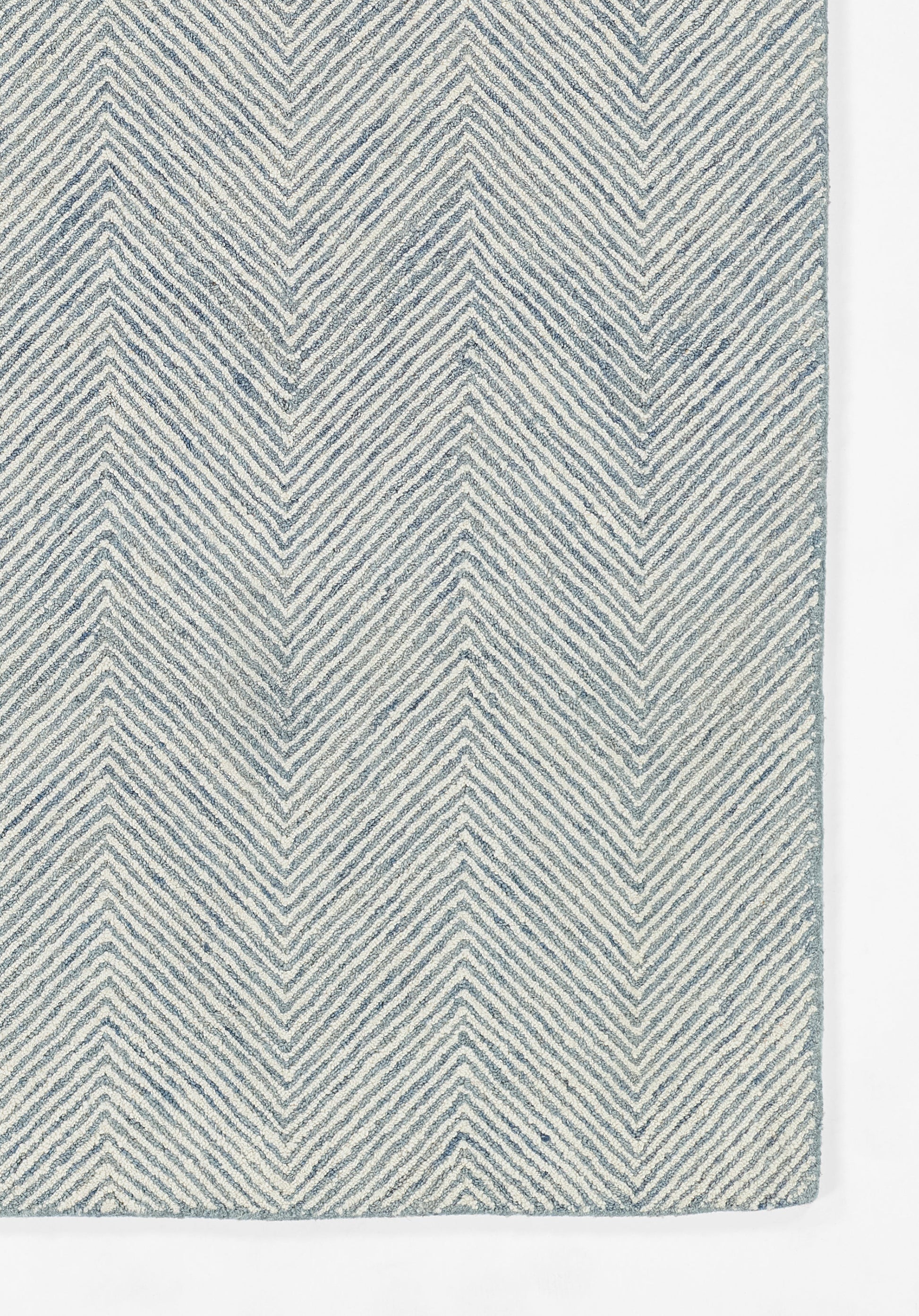 Blue and white chevron-patterned rug with textured woven fibers.