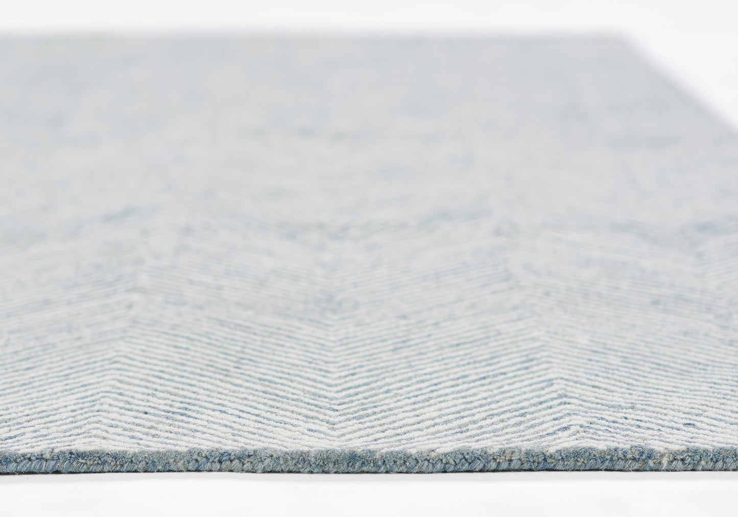 Blue chevron woven rug with light and medium blue stripes, low-pile, modern decor.