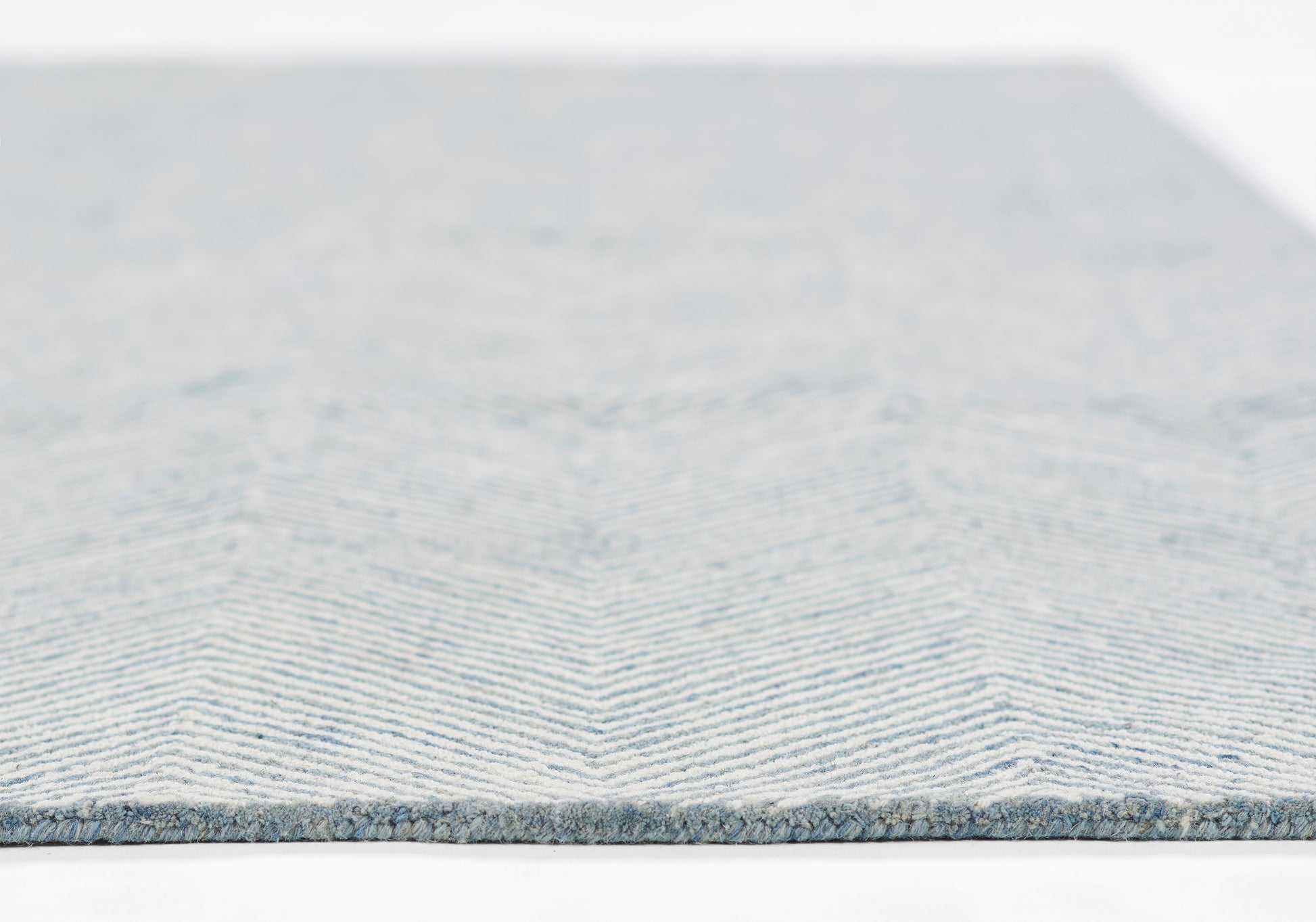 Blue chevron woven rug with light and medium blue stripes, low-pile, modern decor.