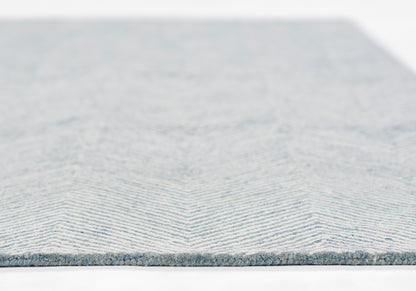 Blue chevron woven rug with light and medium blue stripes, low-pile, modern decor.