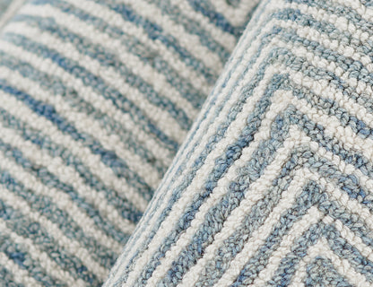 Close-up of a blue and white striped woven rug with a chunky loop pile and soft textured fibers.