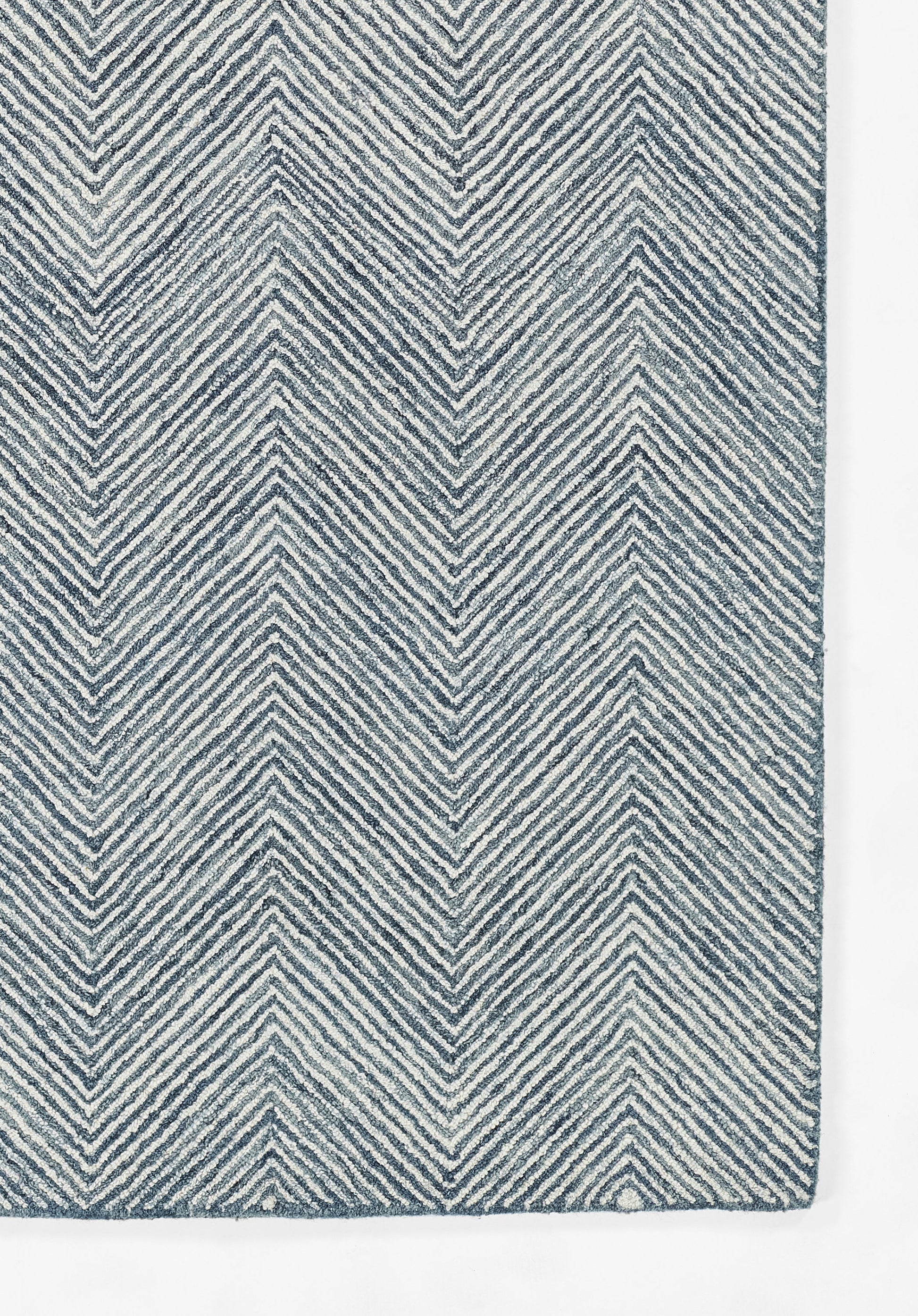 Blue and white chevron woven rug with bold zigzag stripes.
