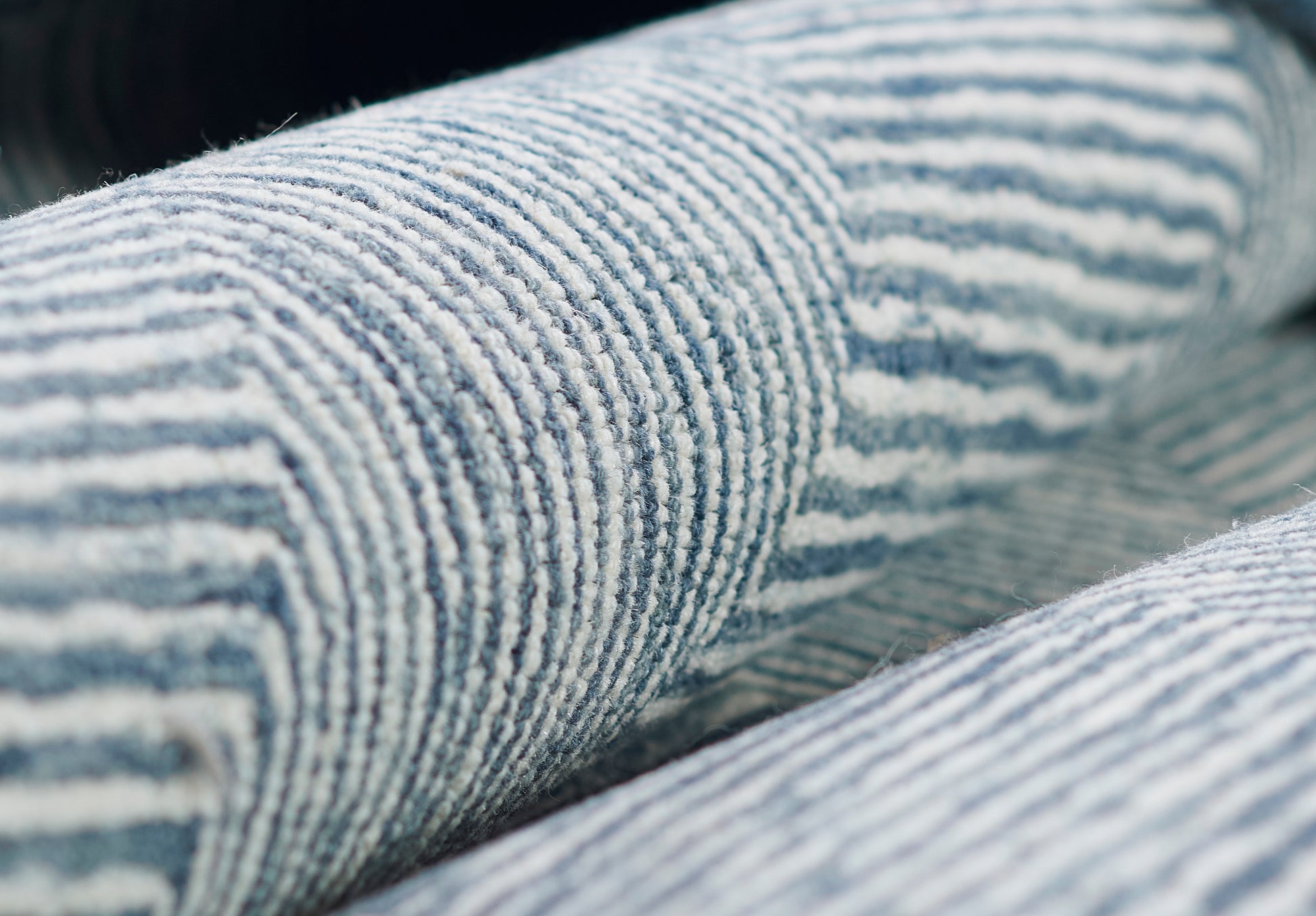 Close-up of blue and white striped corduroy fabric with soft ridges, denim-like texture.
