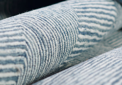 Close-up of blue and white striped corduroy denim fabric with textured ridges.