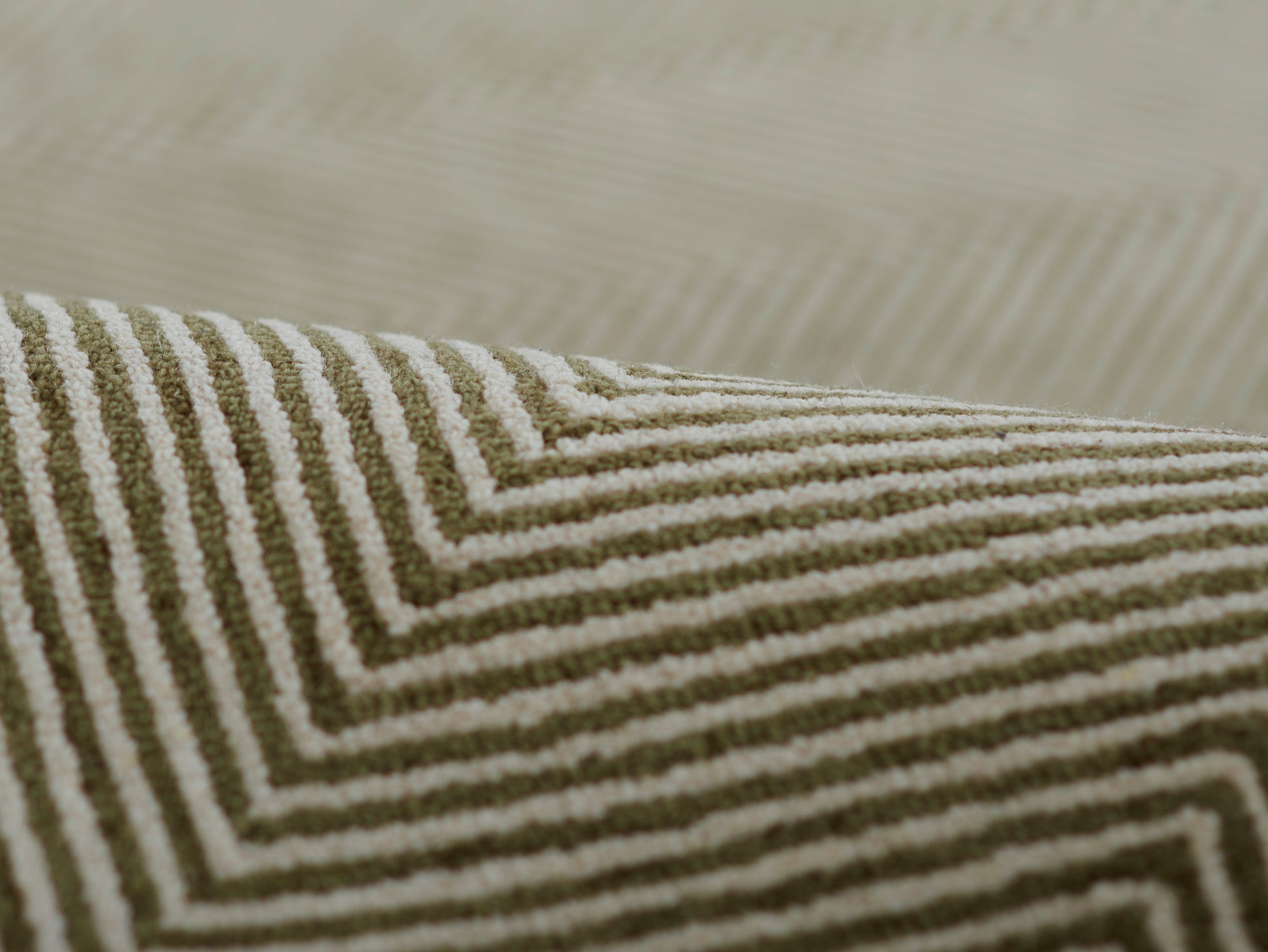 Olive green and cream chevron-striped textured fabric with a geometric concentric pattern.
