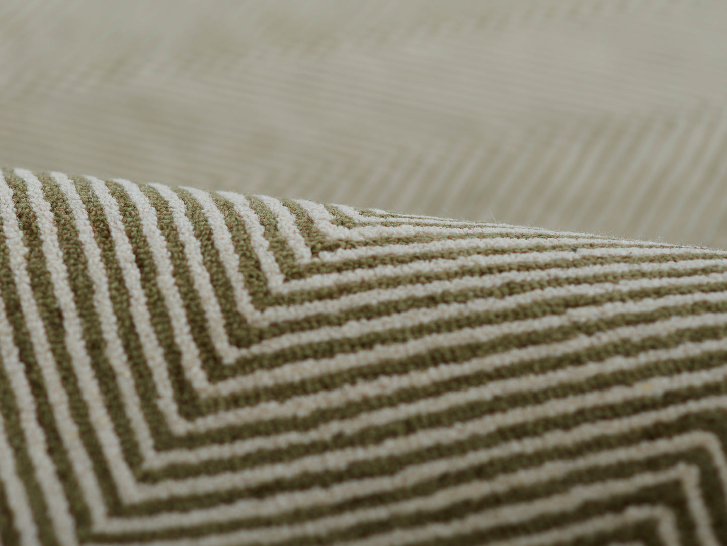 Olive green and cream chevron striped woven rug with a textured pile.