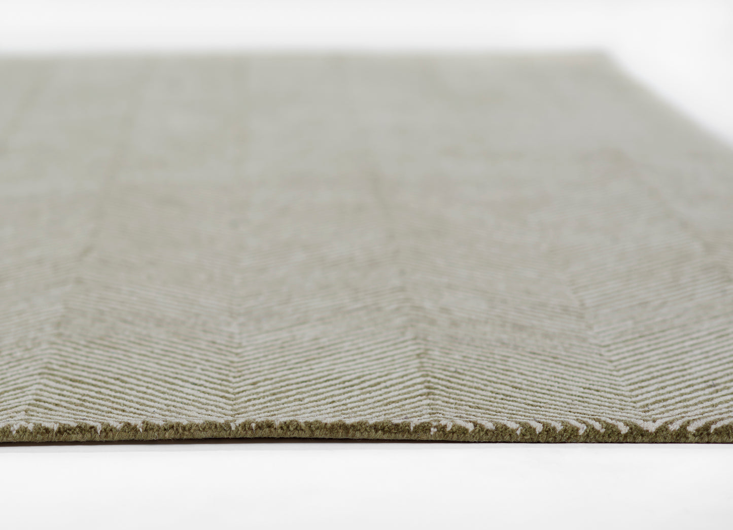 Olive-gray chevron-pattern rug with low-pile flatwoven texture and fringe along edge.
