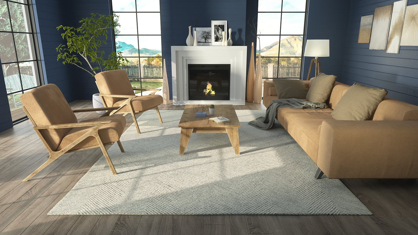 Contemporary living room with blue walls, tan leather chairs and sofa, wooden coffee table, gray rug, and fireplace.