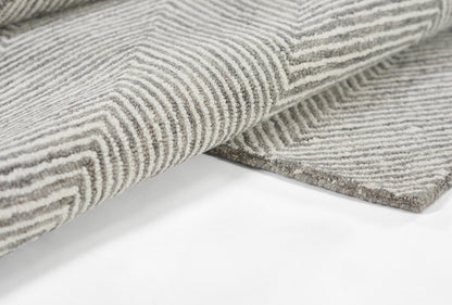 Charcoal gray & white striped rug with geometric chevron pattern and plush looped pile.