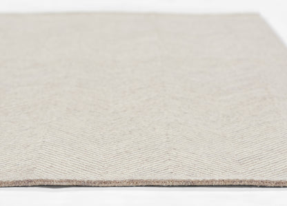 Taupe beige rug with subtle chevron herringbone pattern and fringed edge.