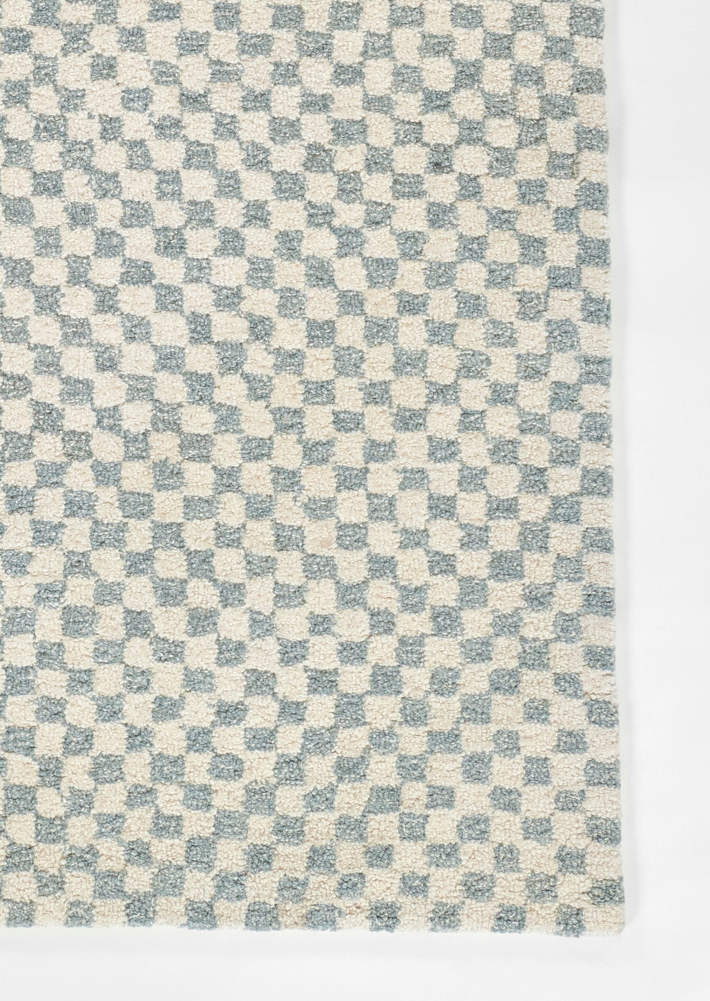 Rectangular woven rug with blue and cream checkerboard pattern, soft textured pile.