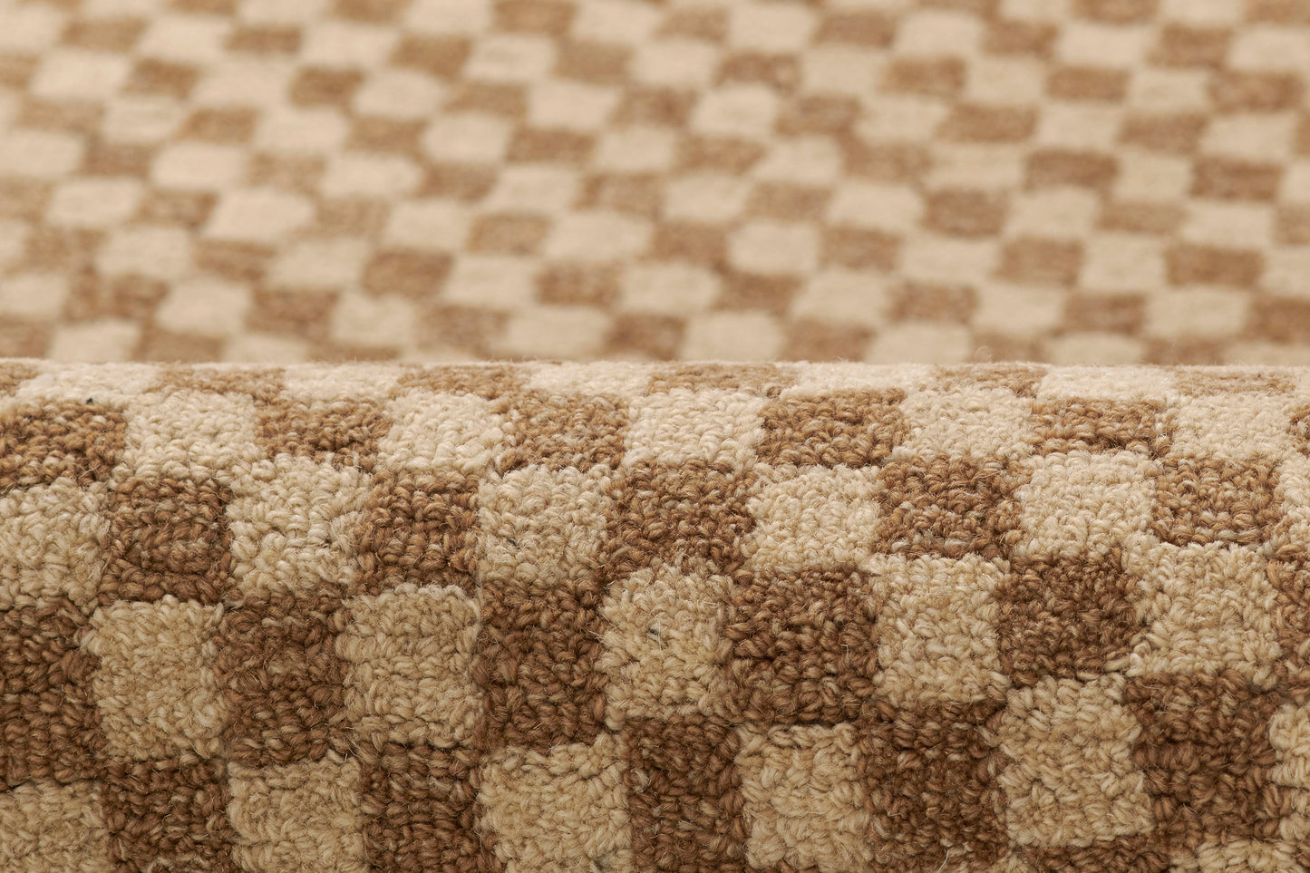 Beige and brown checkerboard shag rug with plush pile and rolled edge, ideal for living rooms.