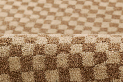 Beige and brown checkerboard shag rug with plush pile and rolled edge, ideal for living rooms.