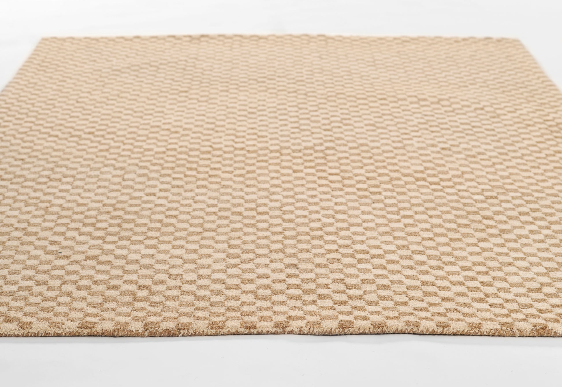 Beige tan low-pile rug with a subtle checkerboard pattern & fringed edges, rectangular living-room rug.