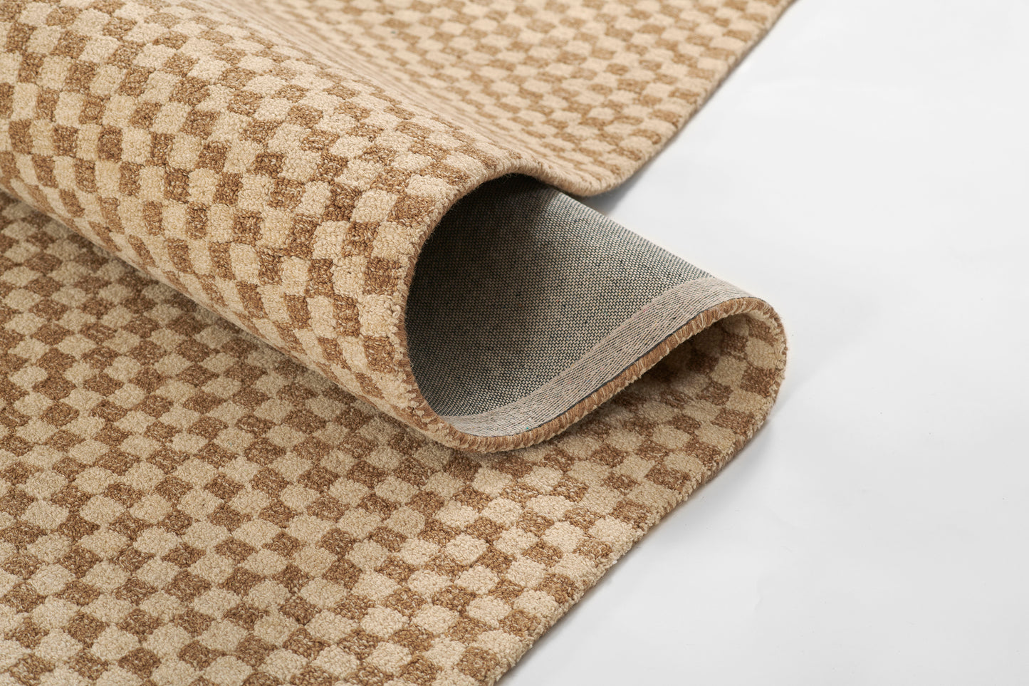 Beige and brown checkered rug rolled up, soft plush pile with bound edge and grey underside.
