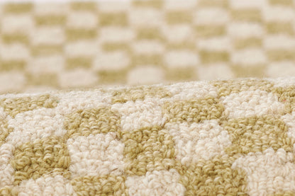 Close-up of olive and cream checkerboard woven rug runner texture in plush tufted yarn.