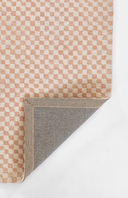 Peach and cream checker-textured rug with beige edge; corner folded to reveal grey fabric underside.