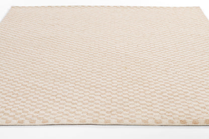 Beige textured area rug with a subtle repeating raised dot pattern in soft, neutral tones.